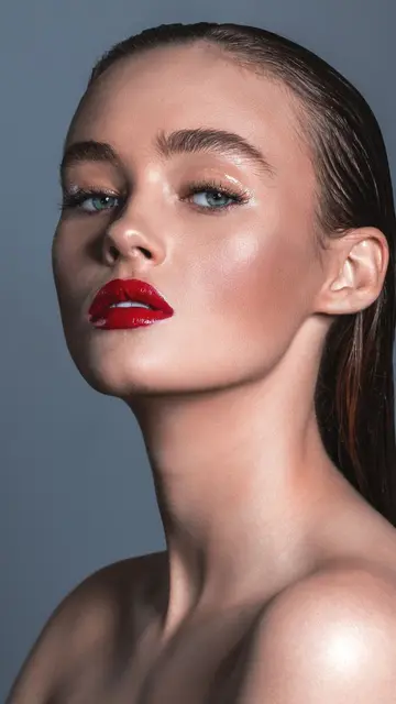Political placement — Studio shot of a woman with sleek hairstyle and glossy red lips, embodying elegance.