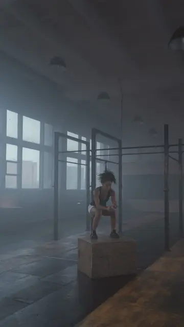 Placement still — A woman focuses intensely in a dimly lit gym, surrounded by fog and workout equipment.